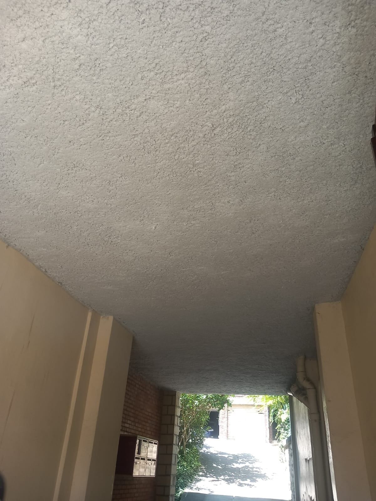 Plafond du passage couvert de l'immeuble recouvert d'isolant projeté